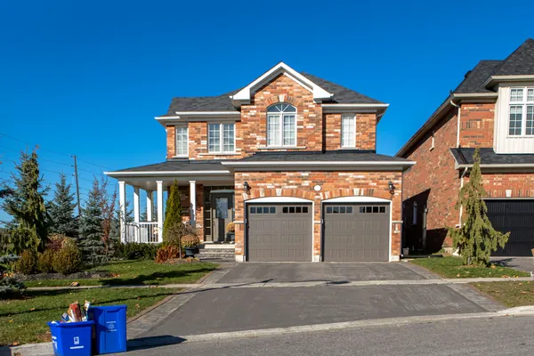 Freshly paved residential asphalt driveway with clean edges beside a lawn