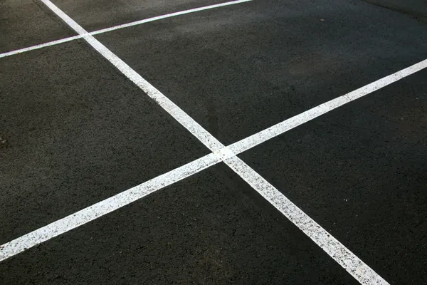 Crisp yellow parking stall lines painted on new black asphalt